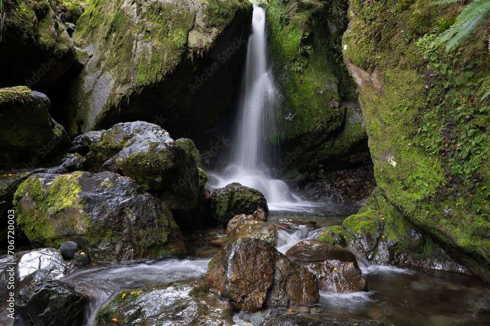 Scenic waterfall in green forest with river and rocks Scenic waterfall in green forest with river and rocks