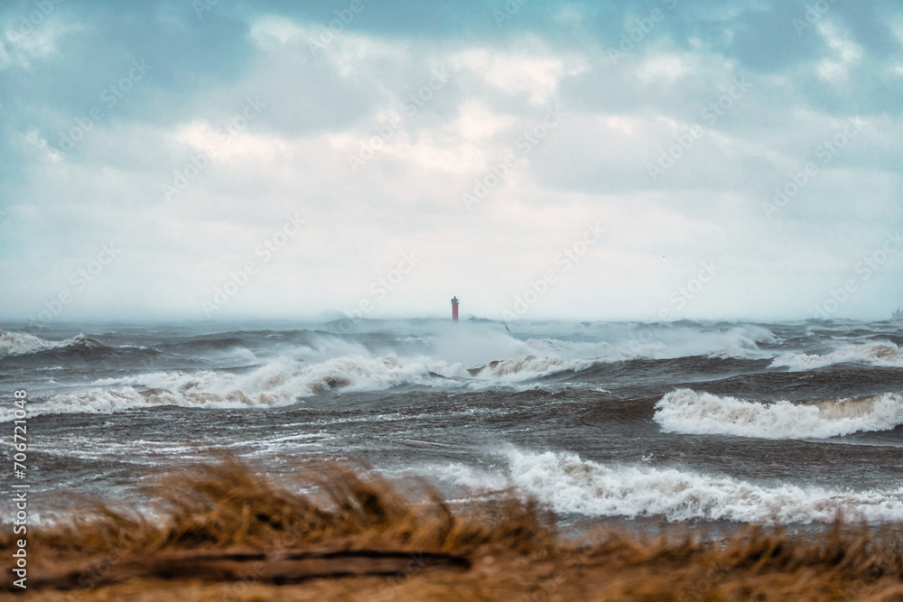 Lighthouse on the sea during Stormy weather in Riga, Latvia. Huge waves crashing down the coast