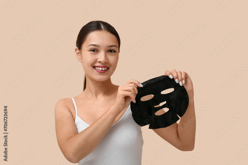 Young woman with activated charcoal mask on beige background Young woman with activated charcoal mask on beige background