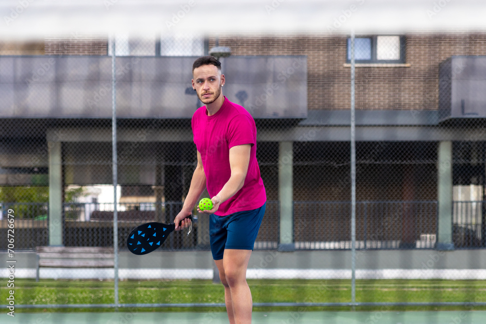 Obraz premium Portrait of a pìckleball player serving during a game.