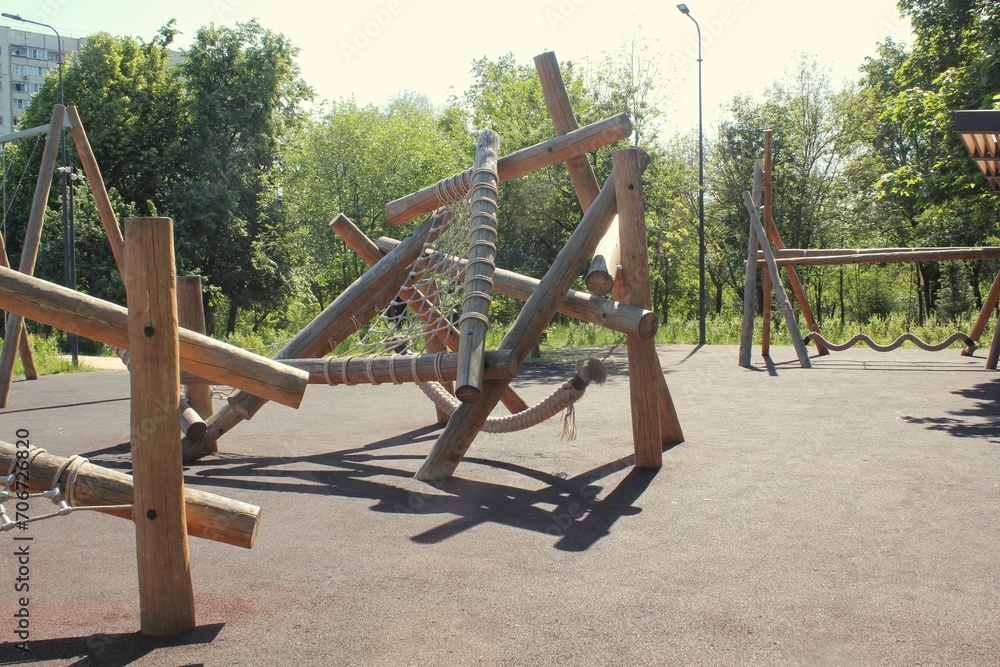 Wooden children playground made of natural eco-friendly material in public city park. Modern safety children outdoor equipment. Concept of sustainable lifestyle and ecology. Rest and games on open air Wooden children playground made of natural eco-friendly material in public city park. Modern safety children outdoor equipment. Concept of sustainable lifestyle and ecology. Rest and games on open air