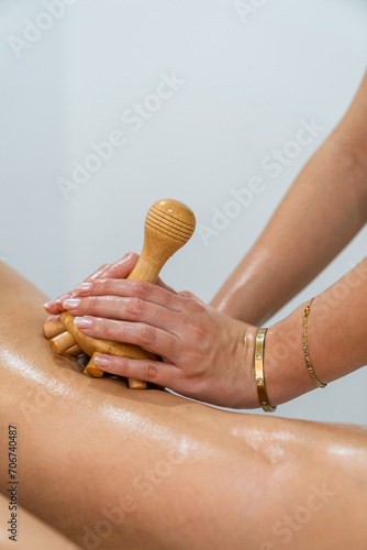 Wallpaper Mural Masseuse performing wood therapy treatment with wooden board on patient's leg Torontodigital.ca