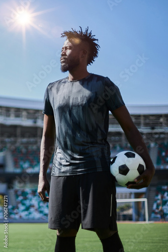 Intense portrait of a football player holding the ball in the stadium