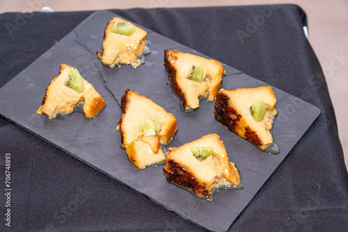 shale stone board with slices of pudding and piece of kiwi