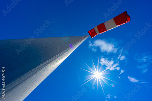 windsock in operation with strong blue sky background with sun photo
