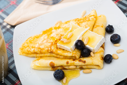 Appetizing pancakes with cheese, honey and nuts. High quality photo