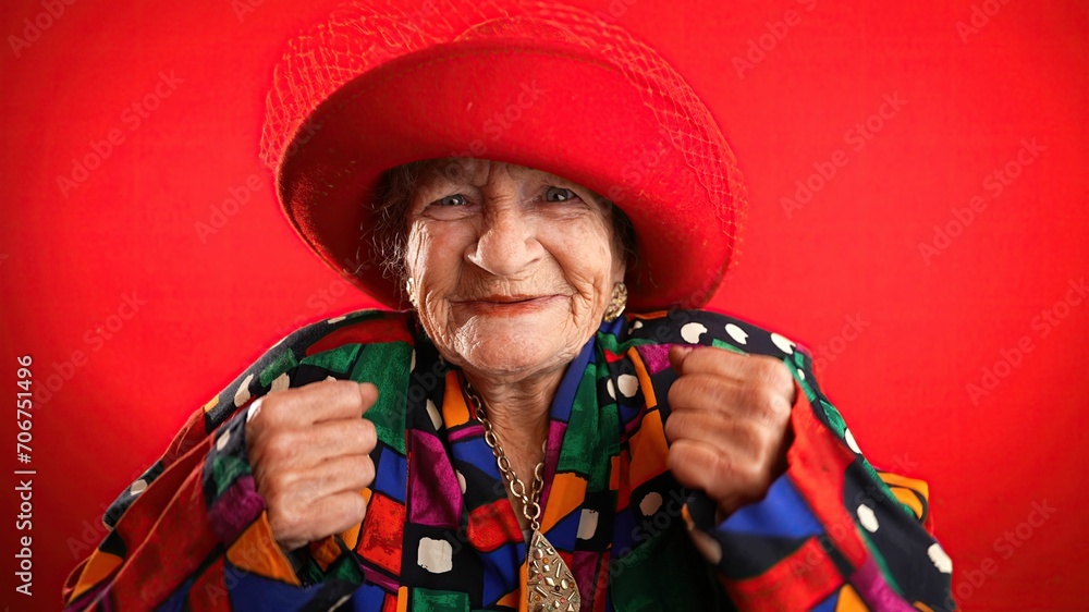 Angry unhappy displeased fisheye portrait caricature of funny elderly woman saying NO with red hat isolated on red background. Angry unhappy displeased fisheye portrait caricature of funny elderly woman saying NO with red hat isolated on red background.