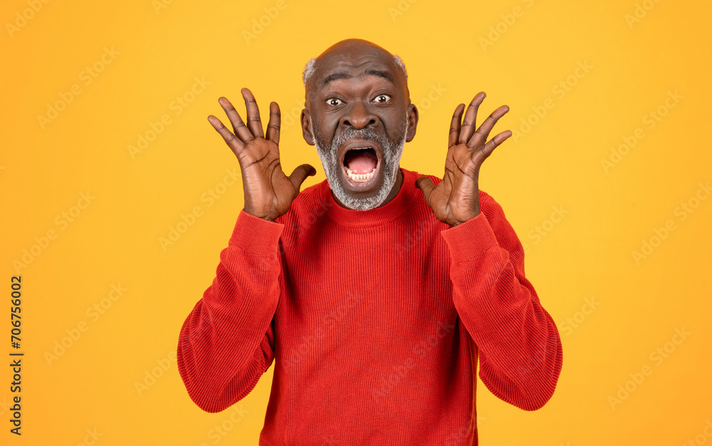Shocked senior Black man with hands raised and an open-mouthed expression of surprise Shocked senior Black man with hands raised and an open-mouthed expression of surprise