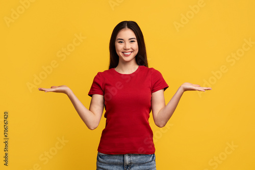 Cheerful young korean woman holding something invisible on both hands