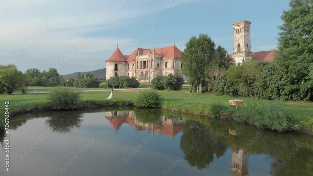 Bride and Groom Walking Close to the Lake and a Castle Bride and Groom Walking Close to the Lake and a Castle