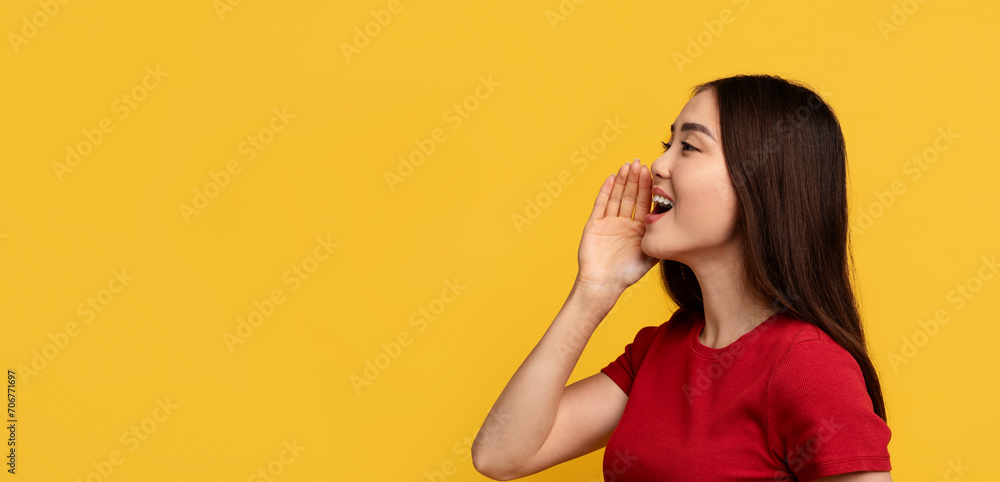 Fototapeta premium Young asian woman screaming towards copy space, yellow background