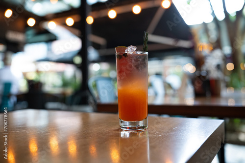 wide shot of orange and clear mouthwatering signature cocktail at cocktail bar during the day