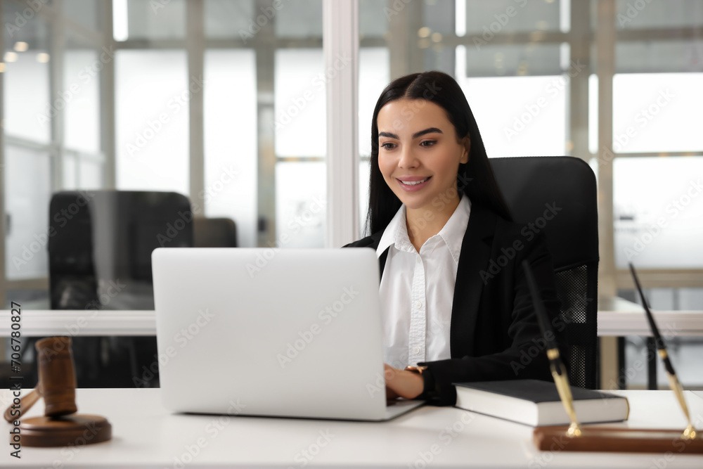 Smiling lawyer working on laptop in office Smiling lawyer working on laptop in office