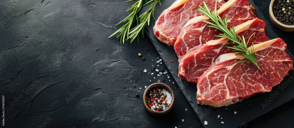 Raw organic meat beef or lamb on a black slate board Top view with copy space. with copy space image. Place for adding text or design