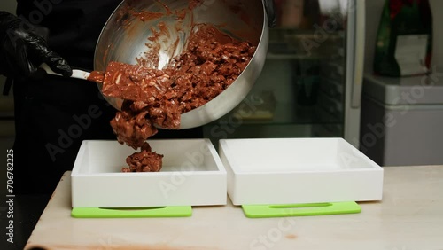 Chef confectioner making chocolate with nuts, dry fruits close-up. Cooking desserts. Bakery and candy market. Cafe and restaurant sweets. photo