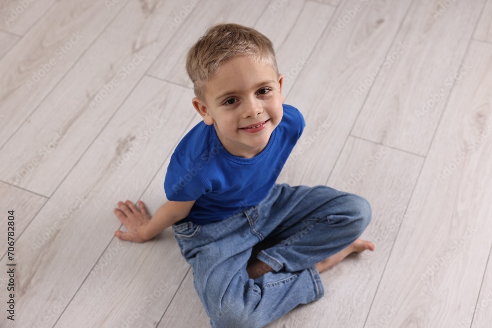 Cute little boy sitting on warm floor indoors. Heating system Cute little boy sitting on warm floor indoors. Heating system