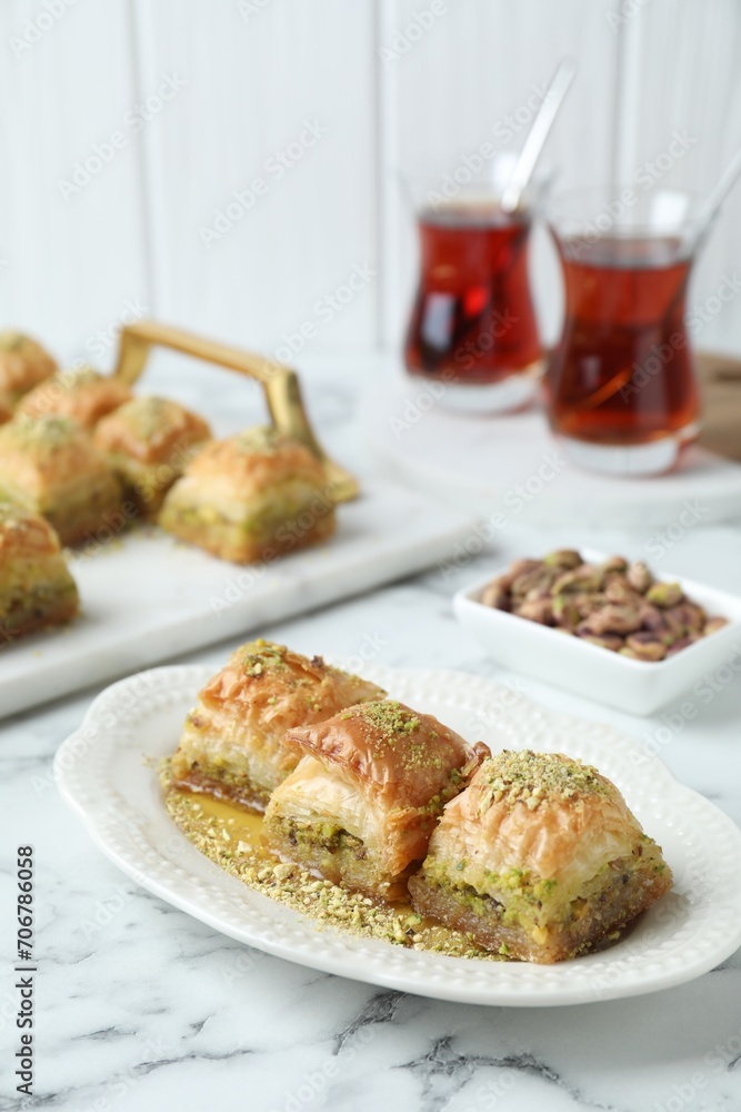 Delicious fresh baklava with chopped nuts and honey on white marble table. Eastern sweets Delicious fresh baklava with chopped nuts and honey on white marble table. Eastern sweets