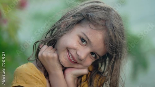 Close-up of a playful 5-year-old girl making silly smiles during her tropical summer vacation, capturing the carefree spirit of childhood photo
