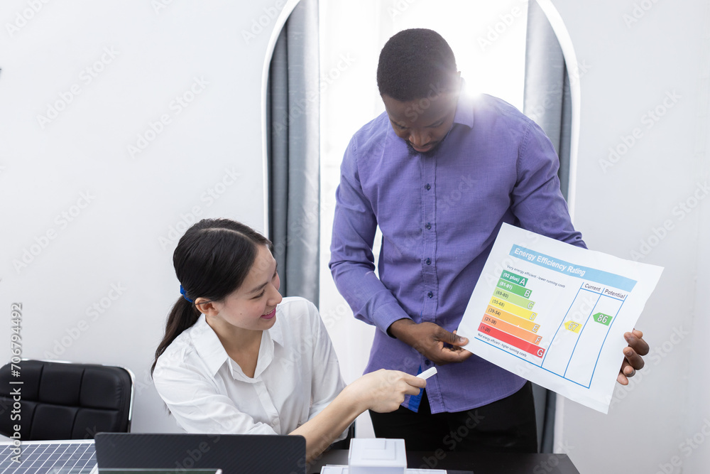 Fototapeta premium Young businessman and businesswoman various nationalities working analysis graph chart report research on document paper brainstorming at table modern office. Investment project and Business concept.