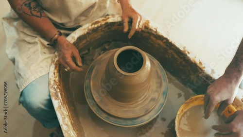 People, hands and clay for pottery, sculpture or ceramics in creativity, art or cylinder shape at workshop. Top view or closeup of sculptor, team or artist with pot mold, craft or handmade startup photo