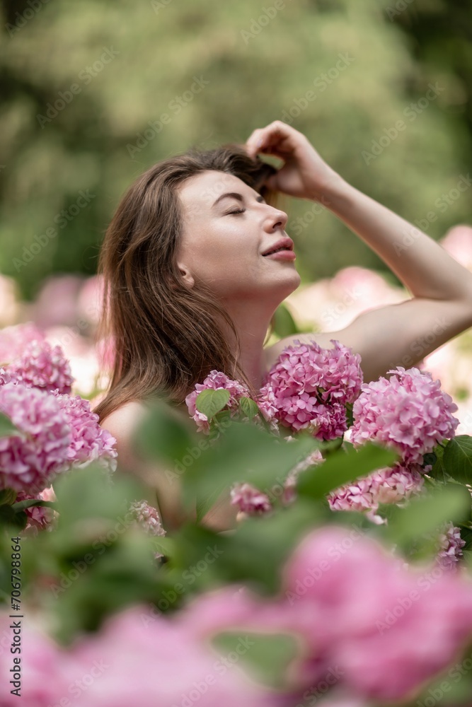 Hydrangeas Happy woman in pink dress amid hydrangeas. Large pink hydrangea caps surround woman. Sunny outdoor setting. Showcasing happy woman amid hydrangea bloom. Hydrangeas Happy woman in pink dress amid hydrangeas. Large pink hydrangea caps surround woman. Sunny outdoor setting. Showcasing happy woman amid hydrangea bloom.