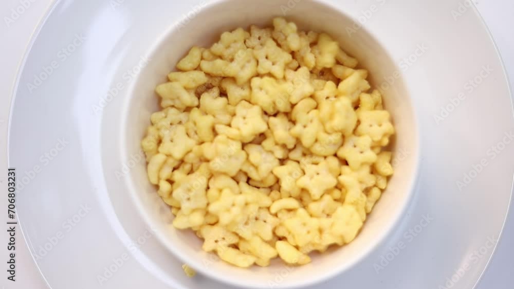 Top view pour cereal, cornflakes into a white bowl, healthy food
Top view pour cereal, cornflakes into a white bowl, healthy food