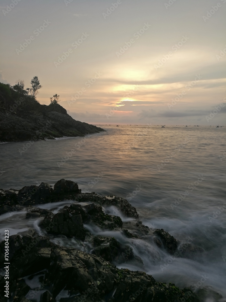 Long exposure of sunset view on a rocky beach in East Java, Indonesia.