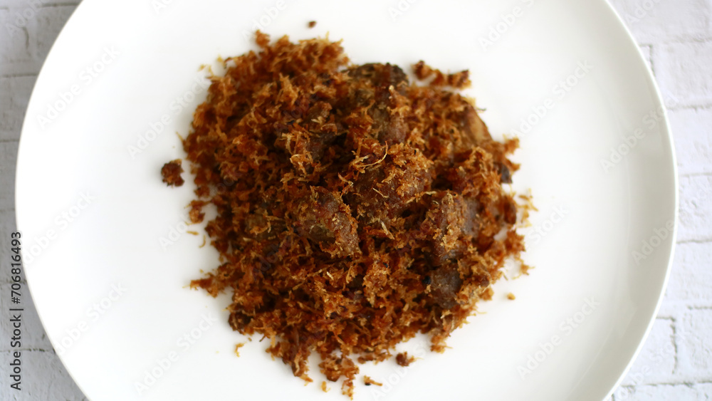 Beef serundeng on white background. Serundeng is an Indonesian food which is made from sauting grated coconut, and is often used as a side dish to accompany rice. Beef serundeng on white background. Serundeng is an Indonesian food which is made from sauting grated coconut, and is often used as a side dish to accompany rice.
