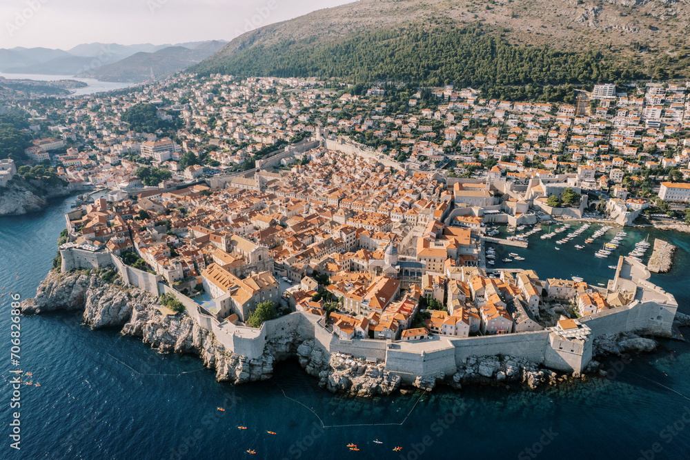 High fortress walls around stone houses in the old town. Dubrovnik, Croatia. Drone