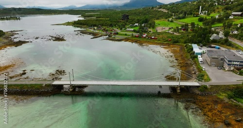 Road Bridge Crossing Tidal Stream Near Oppeid In Hamaroy, Norway. aerial descend, tilt-up photo