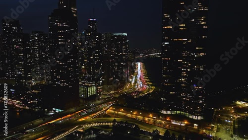 Traffic in front of night lit high-rise of Streeterville in Chicago - Aerial view photo