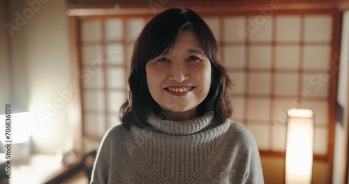 Smile, portrait and mature Japanese woman at her home with positive, good and confident attitude. Happy, proud and face of joyful female person with pride in modern house or apartment in Tokyo Japan. photo