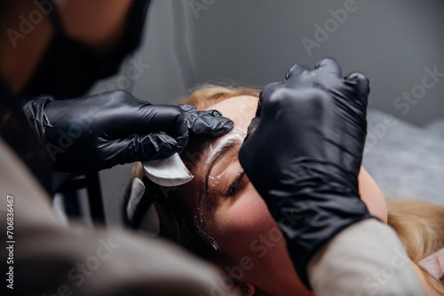 The makeup artist performs permanent makeup. Professional makeup and facial care. Eyebrow and lip tattooing. Cosmetologist. Beauty salon. © Cherkasova Alie