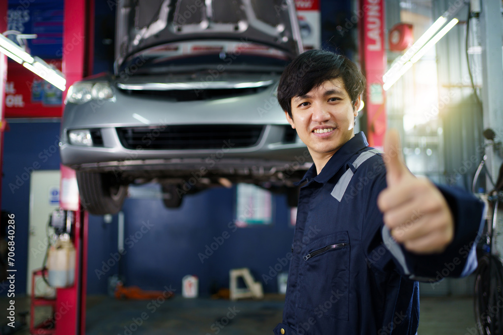 Professional Asian vehicle technician posing for photography in garage. Professional Asian vehicle technician posing for photography in garage.