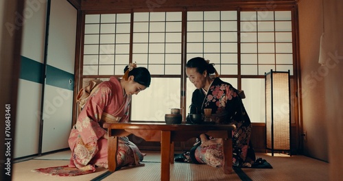 Traditional, home and Japanese women with tea for culture with leaves and herbs in tearoom. Friends, ceremony and people with herbal beverage for wellness, mindfulness and detox for drinking ritual