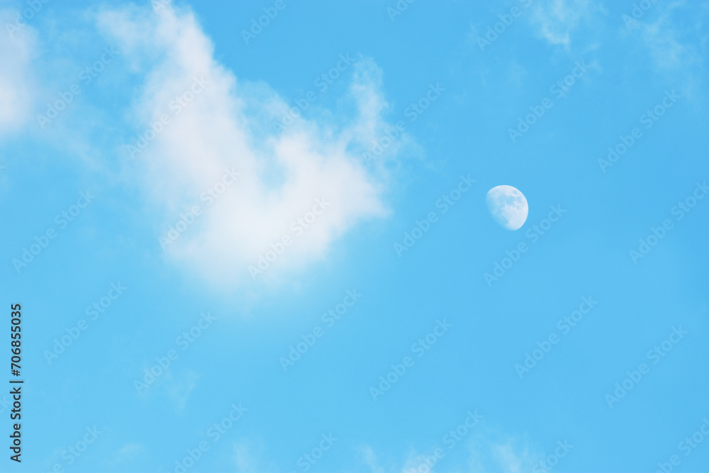 Light blue sky and white clouds and the moon. With copy space. Light blue sky and white clouds and the moon. With copy space.