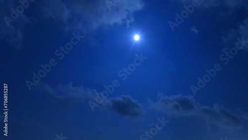 파란 밤 하늘에 하얀 달이 떠 있고 구름이 빠르게 지나가는 미속 촬영 영상 photo