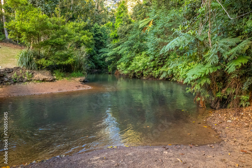 A peaceful river called the North Johnstone River disappears into the tropical rainforest after flowing through the town of Malanda on the Atherton Tablelands in tropical Queensland, Australia.