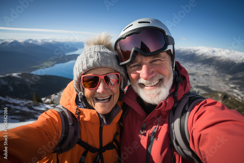 Active sport elderly healthy lifestyle concept. Selfie portrait of senior active smiling mature couple sledding skiing in glasses look happy on top of mountains winter day time, happily retired
