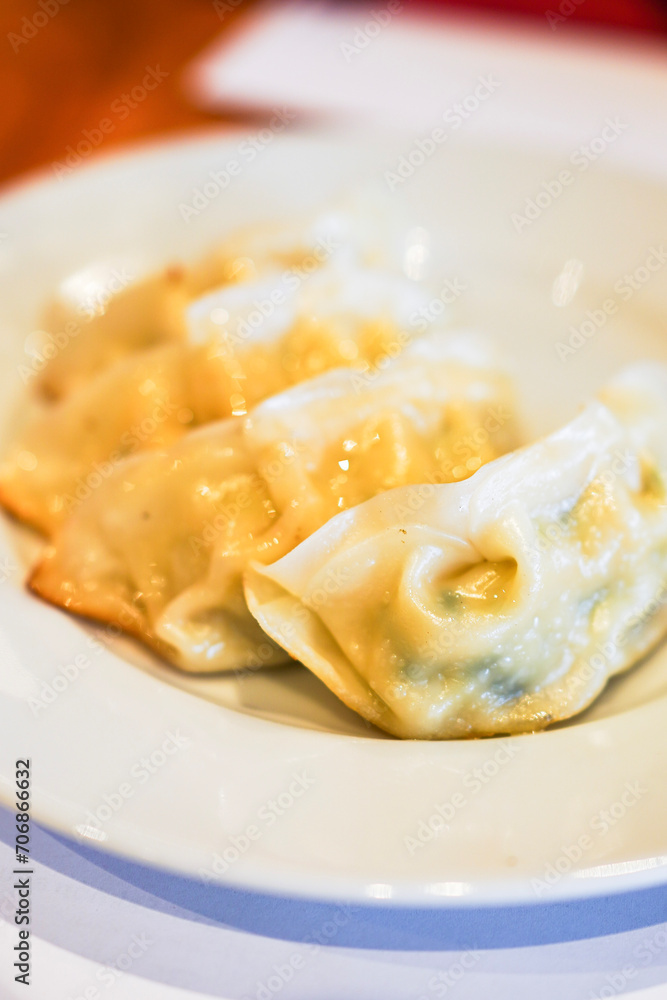 Close-up of steamed dumplings on a white plate.