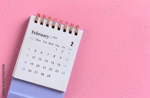 Desk calendar for February 2024 on a pink background with copy space. photo