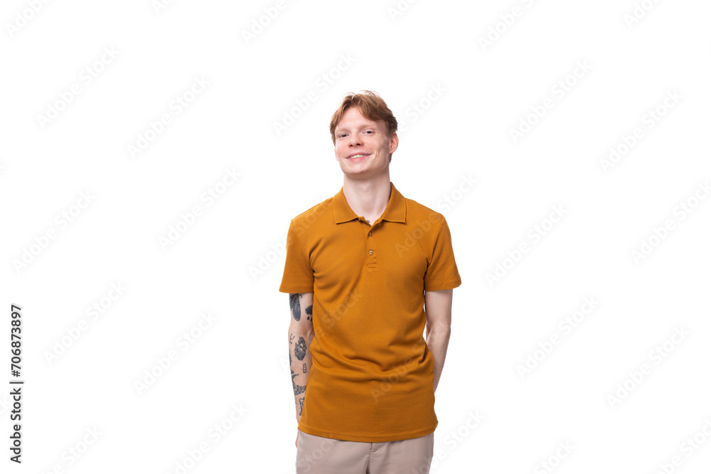 young red-haired man with a short haircut and a tattoo on his arm is dressed in a yellow t-shirt young red-haired man with a short haircut and a tattoo on his arm is dressed in a yellow t-shirt
