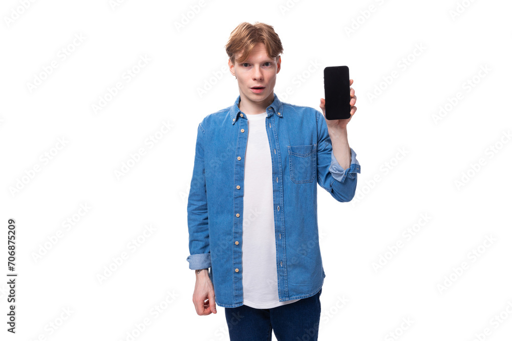young redhead guy in a blue denim shirt shows a smartphone screen mockup with copy space young redhead guy in a blue denim shirt shows a smartphone screen mockup with copy space