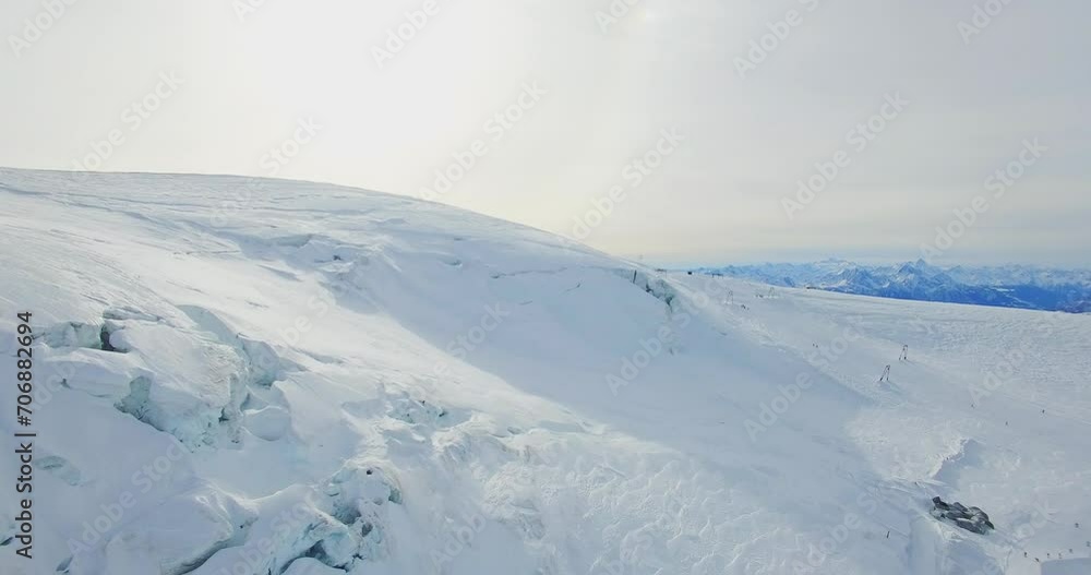 Pristine snow-capped landscapes in Switzerland, where the drone captures the pure beauty of the white expanse, creating a winter wonderland spectacle with some skiers in the far distance. Pristine snow-capped landscapes in Switzerland, where the drone captures the pure beauty of the white expanse, creating a winter wonderland spectacle with some skiers in the far distance.