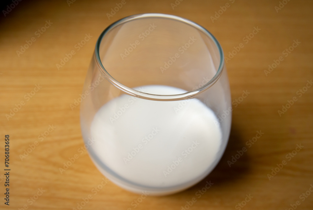 a glass of milk on a table with a wooden patterned background a glass of milk on a table with a wooden patterned background
