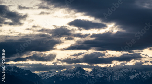 Wolken über den verscheniten Ammergauer Alpen und dem Wettersteingebirge mit gelbem Winterhimmel, Hohenpeißenberg, Bayern,. Deutschland 