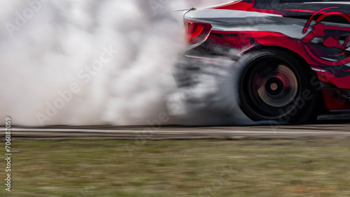 Blurred car drifting diffusion race drift car with lots of smoke from burning tires on speed track, Professional driver drifting car on race track with smoke. photo