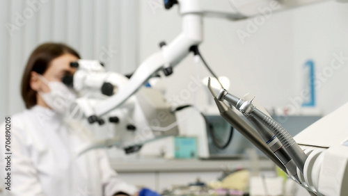 Portrait of a female dentist at work in dentistry in a white coat, busy with the work process. Concept of in-demand professions, medicine and dental services.