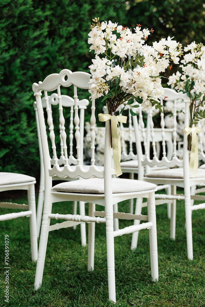  wedding chair decorated with white flowers in nature.Close-up