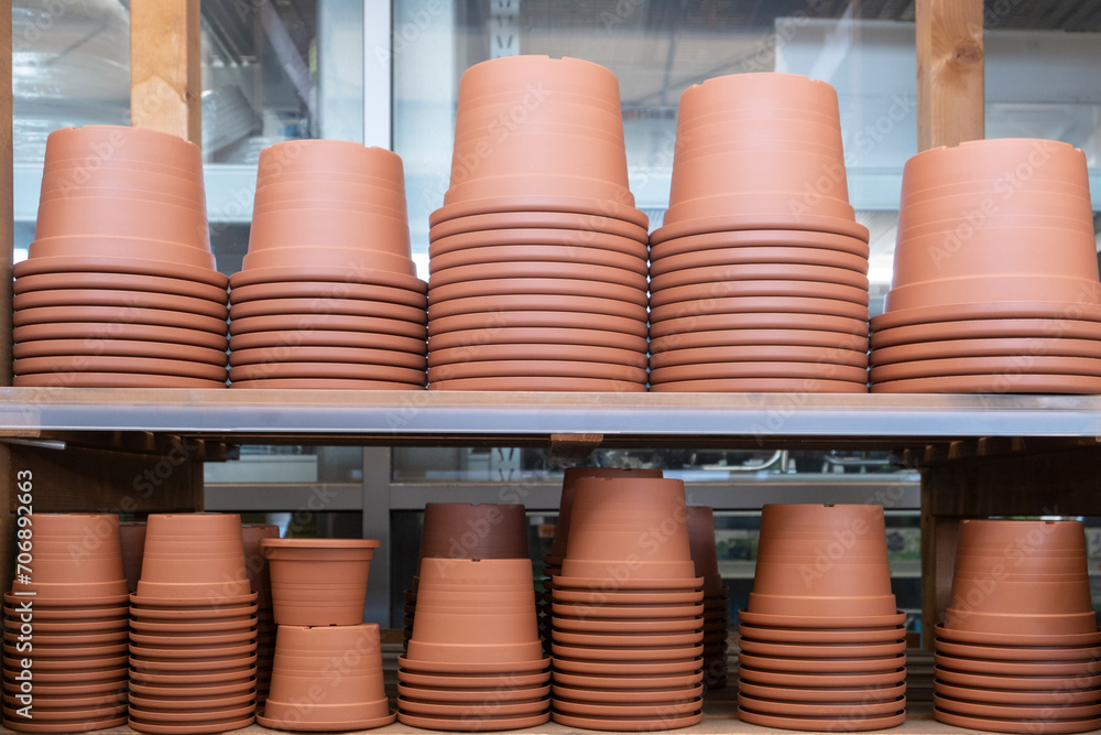Empty garden Plastic Pots in a row on the metal shelf in the hardware store. Spring Gardening concept Empty garden Plastic Pots in a row on the metal shelf in the hardware store. Spring Gardening concept